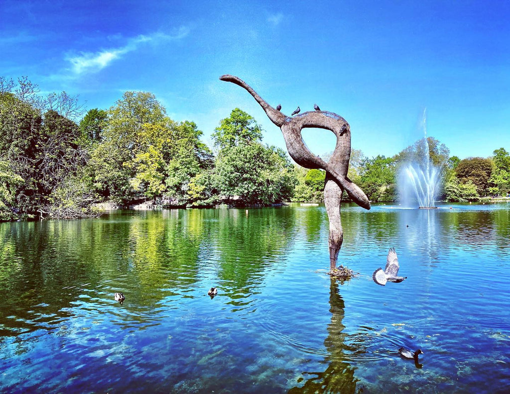 Lake with monument and birds under clear blue sky